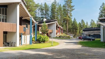 A residential area with modern houses, a gravel driveway, and a car parked in the distance.