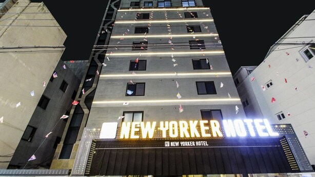 The exterior of the New Yorker Hotel with its distinctive architecture and illuminated signage. - New Yorker Hotel (Jinju)