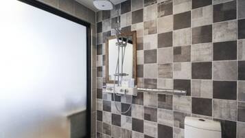 A modern bathroom with a shower, tiled walls, and a toilet.