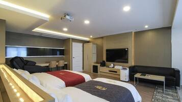 Una habitación de hotel moderna con dos camas, televisión, sofá, cafetera y un ventanal grande.