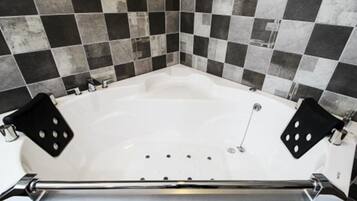 A white bathtub with black and white checkered tiles on the walls.