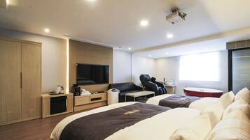 A modern hotel room with two beds, a flat-screen TV, a massage chair, a small table, and a window with a view.