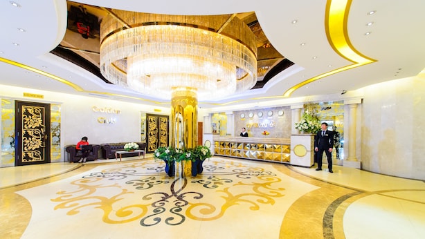 Eine luxuriöse Lobby mit einem prächtigen Kronleuchter, einer Rezeption und einer Lounge.