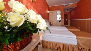 Ein Hotelzimmer mit einem Bett, einem Korbwesen mit Blumen und einer Wand mit einem Blumenmuster.