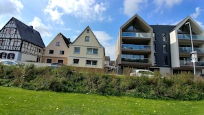 A row of residential buildings with varying architectural styles, including a traditional half-timbered house and modern apartment buildings.