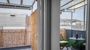 A balcony with a view of a cityscape, a table with a bottle and glasses, and a chair. - Nest Studio with Terrace, Acropolis View (Athens)