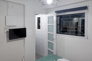Cozy retreat with a flat-screen TV, frosted glass door, and geometric-patterned window.