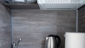 A modern kitchen with a built-in dishwasher, a kettle, and a coffee maker. - Nest Studio with Terrace, Acropolis View (Athens)