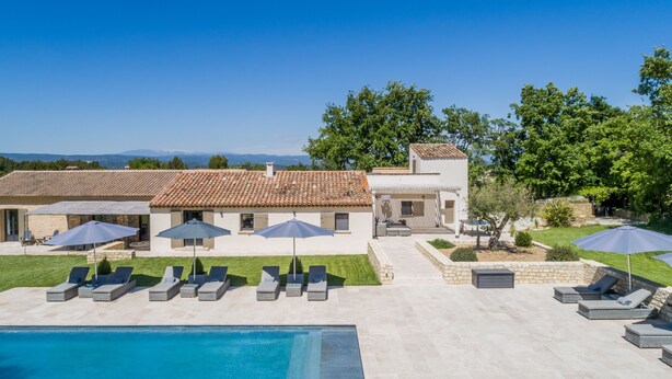 A pool area with lounge chairs and umbrellas, a stone patio, and a view of the surrounding landscape. - Superb 5 * rated property with spectacular view in Ménerbes (Menerbes)