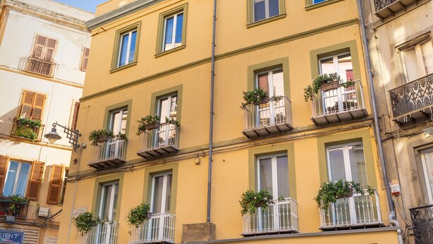A multi-story building with a storefront labeled "motivi". - Janna 'e Mare (Cagliari)