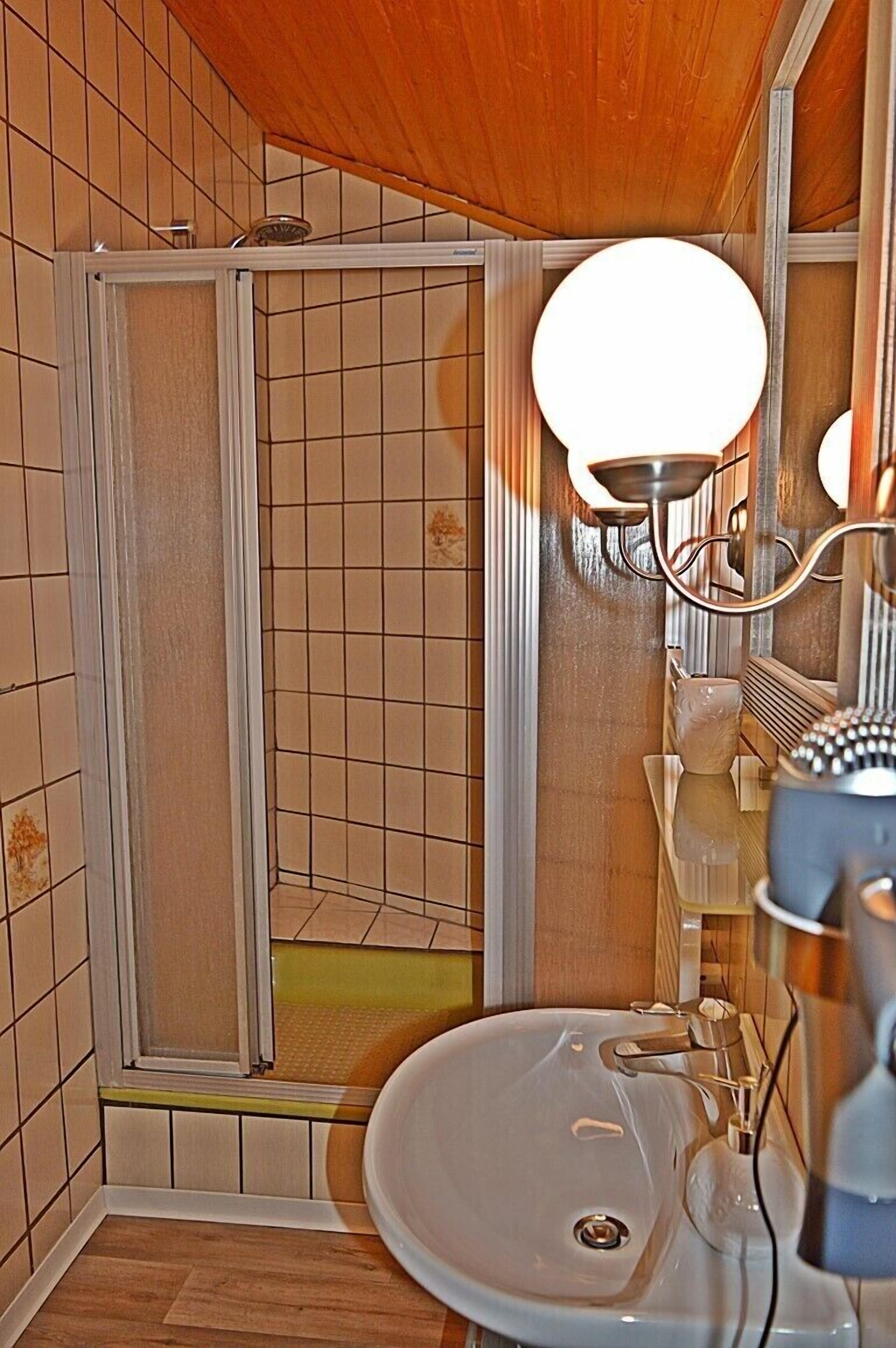 A bathroom with a shower, a sink, and a mirror.