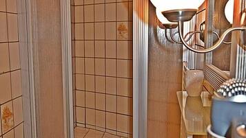 A bathroom with a shower, a sink, and a mirror.