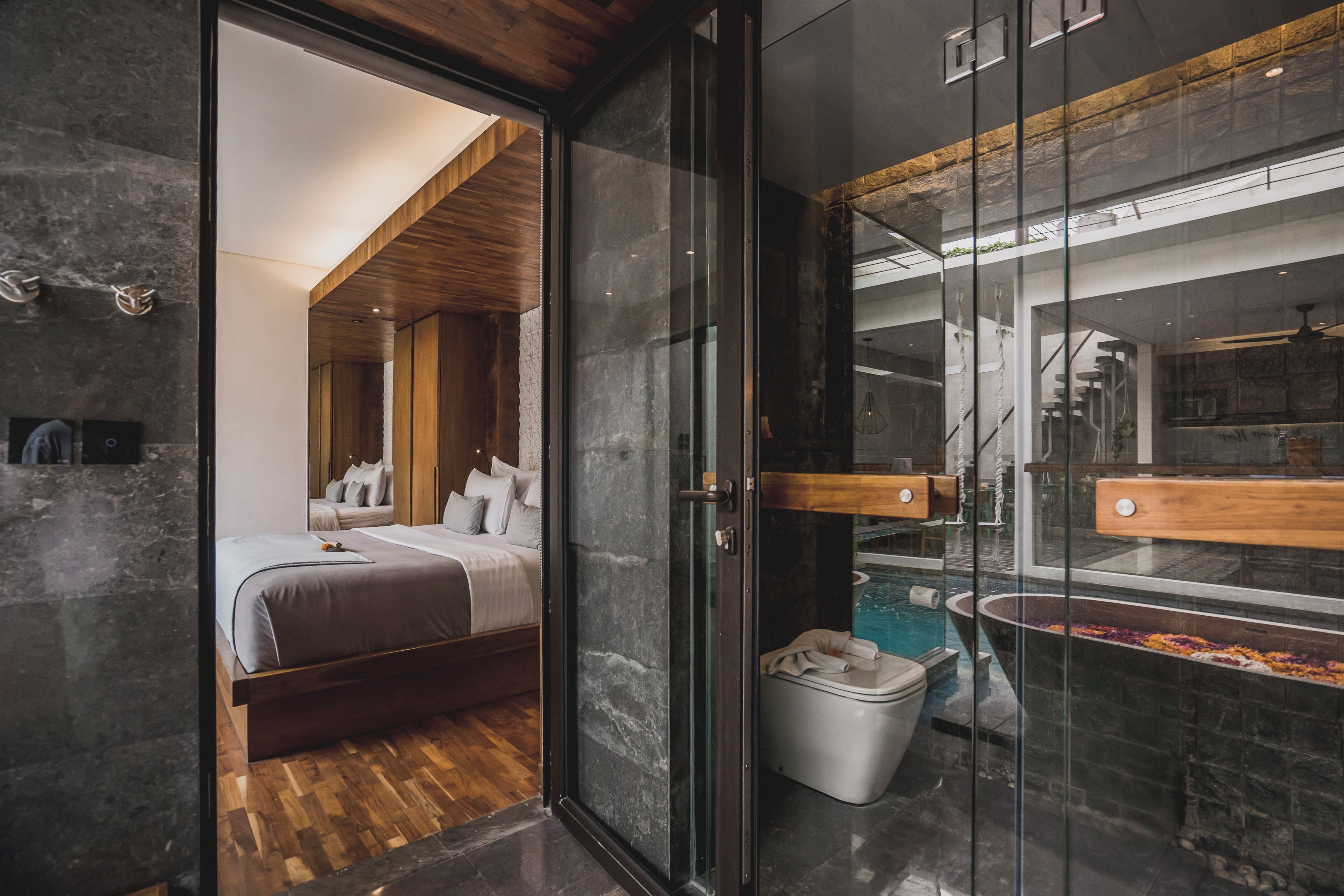A modern bathroom with a glass shower enclosure, a bathtub, and a toilet.