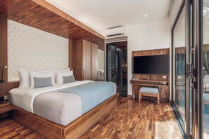 A modern bedroom with a large bed, wooden flooring, a TV, and a glass door leading to a balcony. - Ayona Villa Seminyak by Ini Vie Hospitality (Kerobokan)