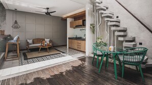 Un espacio habitable moderno con zona de comedor, cocina y escalera.
