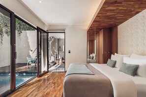 A modern bedroom with a large bed, a wooden ceiling, and a sliding glass door leading to a pool area. - Ayona Villa Seminyak by Ini Vie Hospitality (Kerobokan)