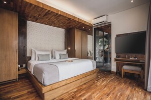A modern bedroom with a wooden bed frame, a flat-screen TV, and a walk-in closet.