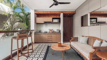 A modern kitchen with wooden cabinets, a ceiling fan, and a dining area with a round table and chairs.
