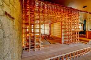 Um quarto em estilo japonês tradicional, com tatames, portas corrediças de madeira e uma mesa baixa de madeira.