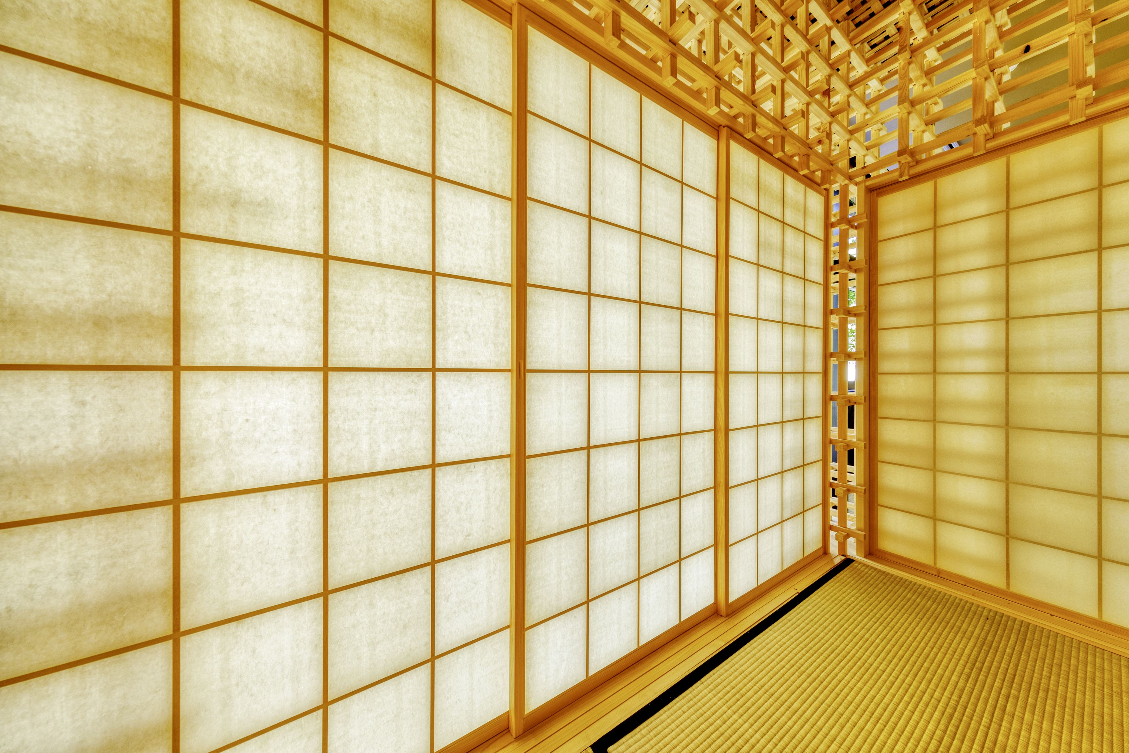 Ein traditioneller japanischer Raum mit Tatami-Böden, Shoji-Schirmen und einer Holzdeckenkonstruktion.