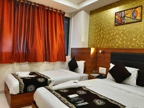 A hotel room with two beds, a wooden headboard, and a decorative wall. - Hotel Aiston Inn (Mumbai)