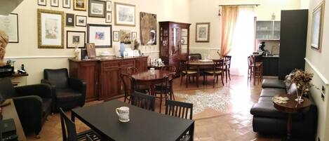 Un salón amplio con comedor, una cocina al fondo y una mesa de comedor con sillas.