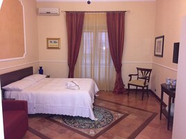 Una habitación de hotel con una cama, una silla, una mesita y una alfombra.