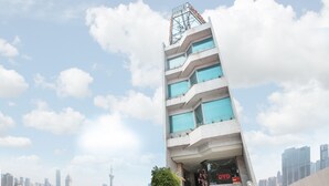 A modern hotel with a unique architectural design, featuring multiple balconies and large windows. - OYO 671 Hotel Capitol (Jakarta)