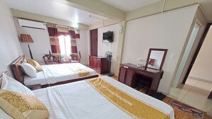 Une chambre d’hôtel avec deux lits, un bureau, un miroir, une télévision et une armoire.