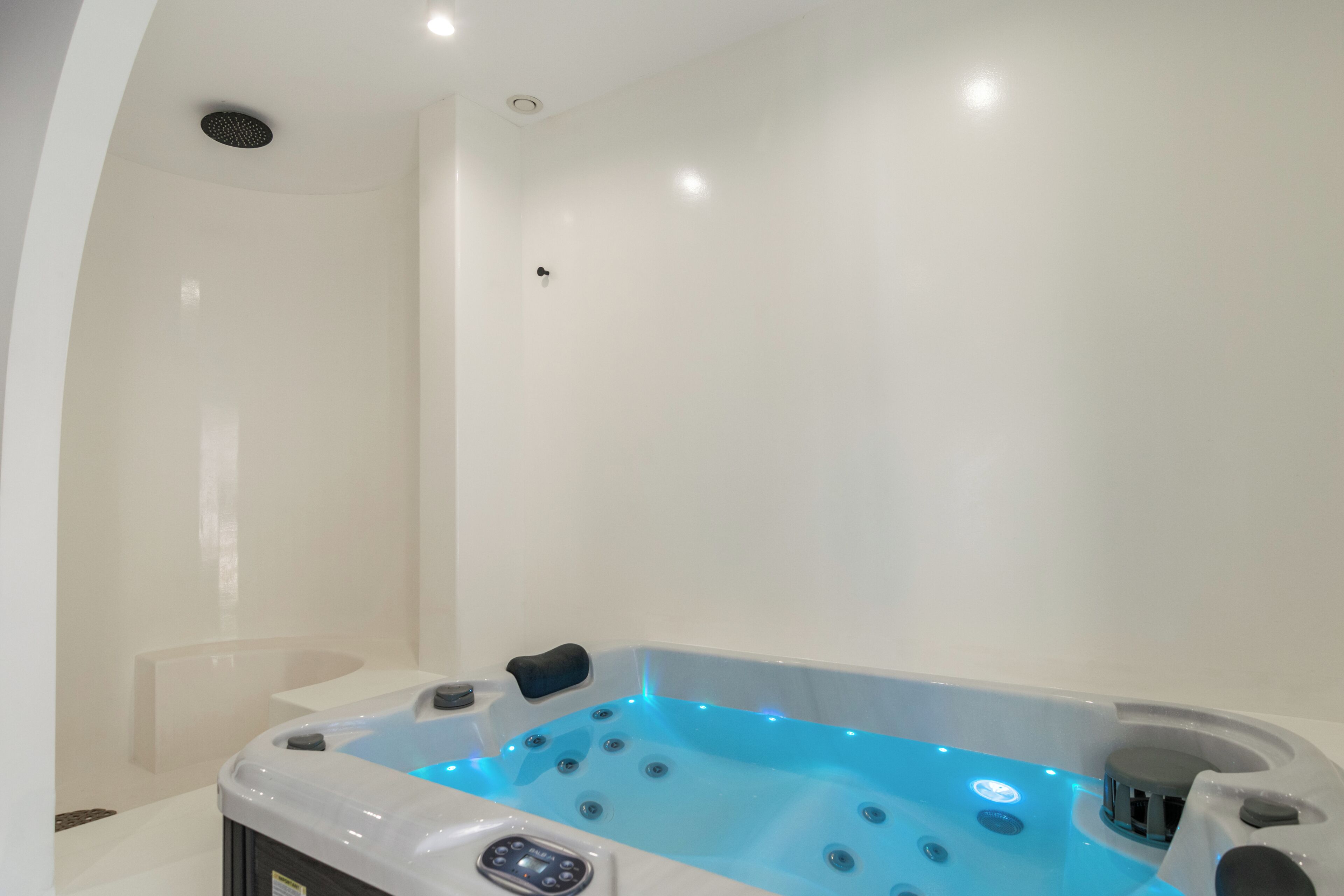 Un baño moderno con una bañera grande, un panel de control y una zona de ducha.