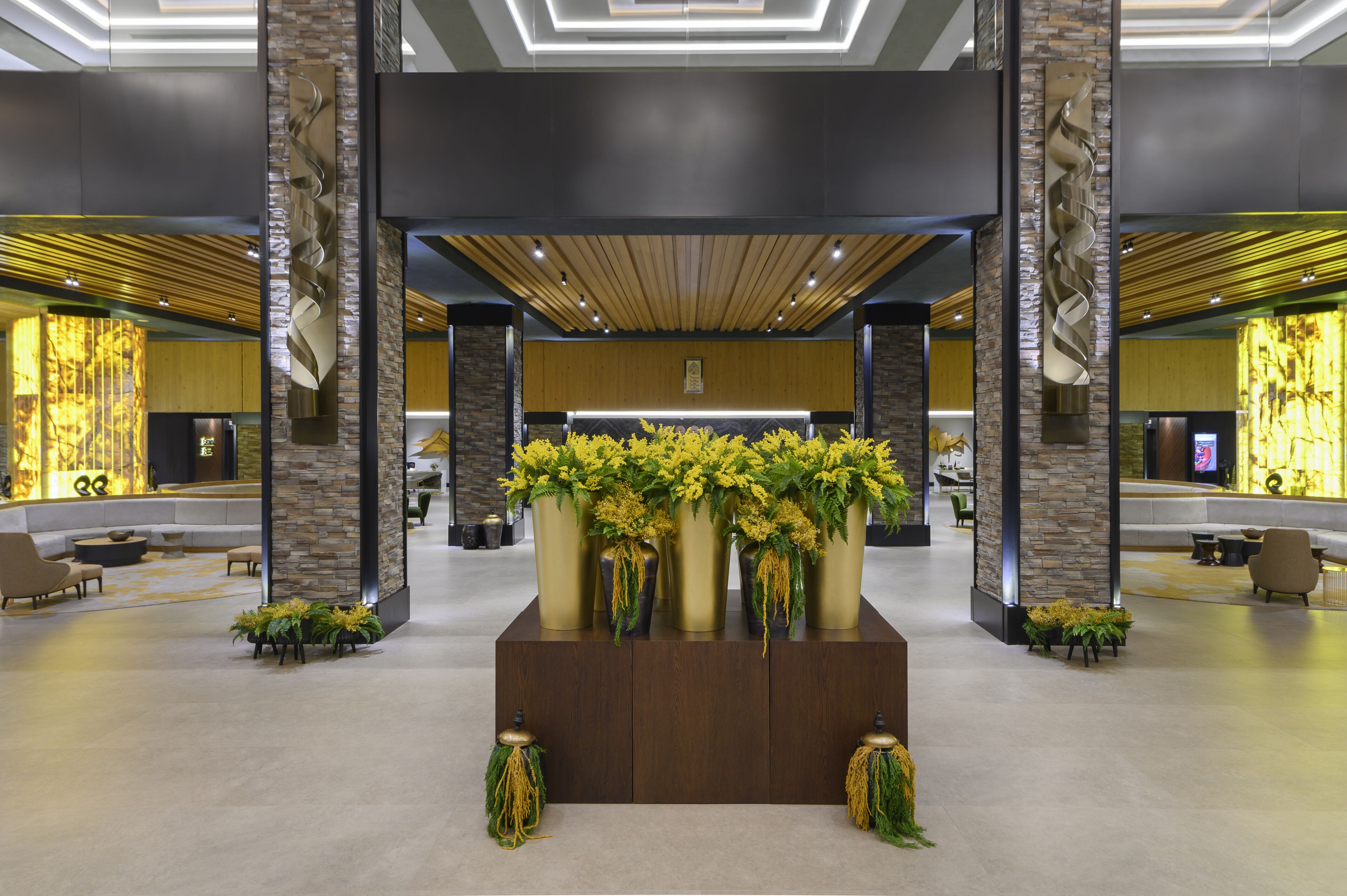 A lobby with a reception desk, seating area, and decorative plants.