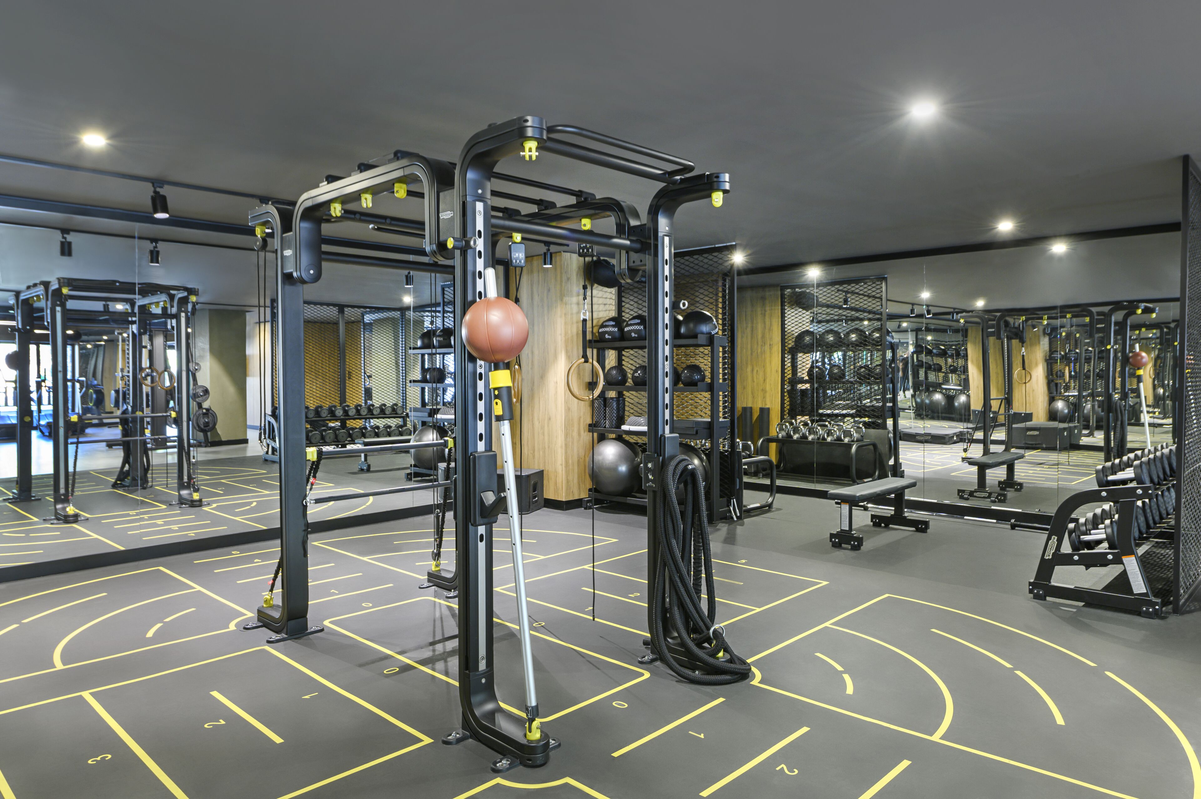 A gym with various exercise equipment, mirrors, and a patterned floor.