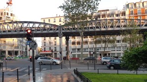 A street scene with a pedestrian crossing, traffic lights, and a metal bridge overhead. - PARIS_BNF Economical, comfortable studio close to Bercy BNF and Jardin Plantes (Paris)