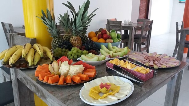 A table with various fruits and cheeses. - Pousada Porto Riomar (Ipojuca)