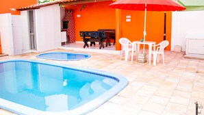 A swimming pool with two hot tubs, a barbecue area, and outdoor seating. - Pousada Porto Riomar (Ipojuca)