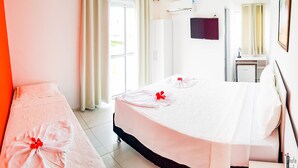 A hotel room with a large bed, a bedside table, a mirror, and a window with curtains. - Pousada Porto Riomar (Ipojuca)