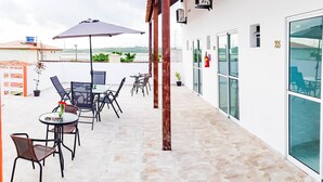 A terrace with outdoor seating, a fire extinguisher, and a view of the landscape. - Pousada Porto Riomar (Ipojuca)