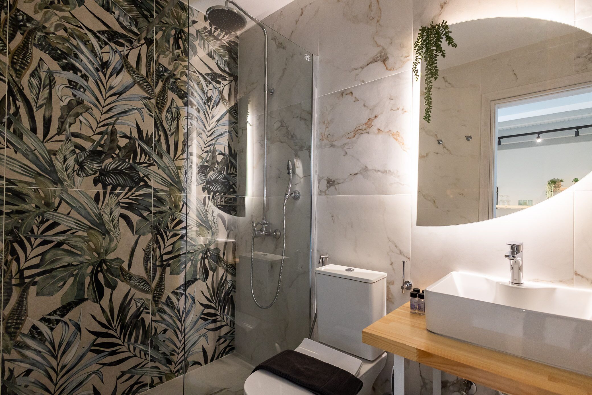 A modern bathroom with a shower, toilet, and sink.