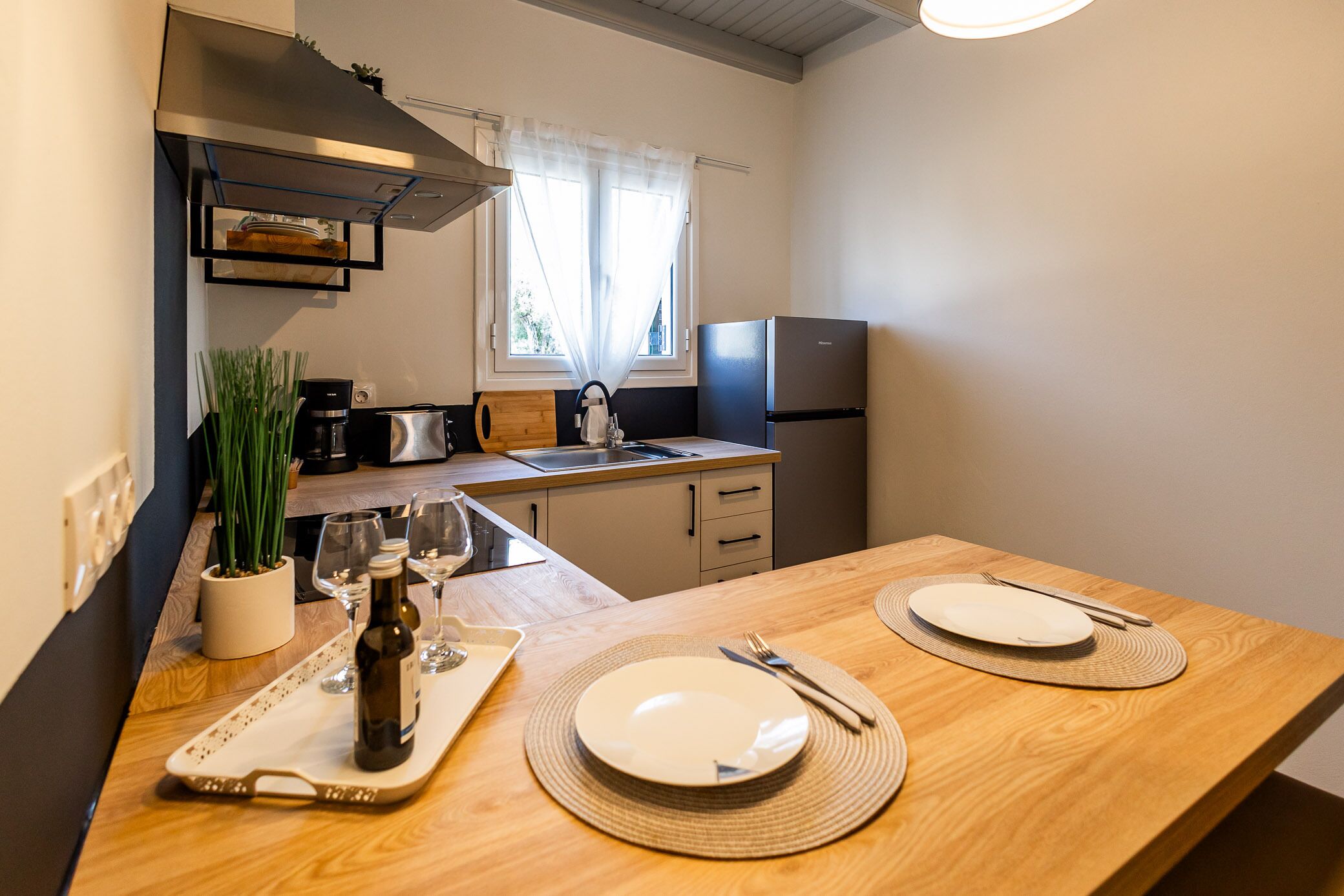 A modern kitchen with a wooden countertop, a built-in stove, and a refrigerator.