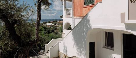 A two-story building with a stone staircase leading to a balcony.