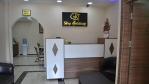 Un área de recepción con un mostrador, un cartel que dice "KAFALTI SALONU" y un logotipo sobre el mostrador.