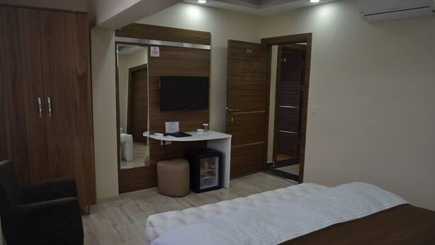 Un dormitorio con cama, escritorio, silla y armario.