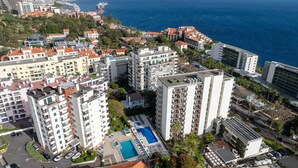 Un hôtel de grande hauteur doté de nombreux balcons, d’une piscine et offrant une vue sur la mer.