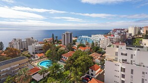 Un hotel costero con varias construcciones, una piscina y vistas al mar.