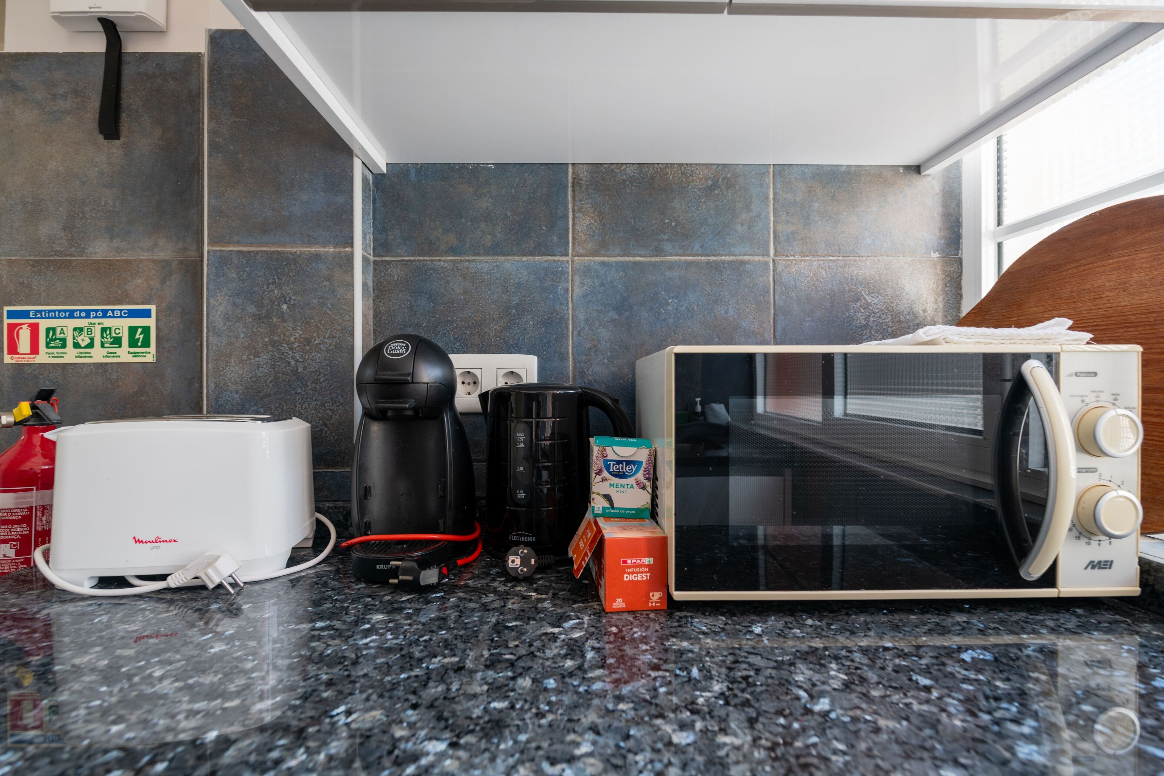 Eine Küche mit Toaster, Kaffeemaschine, Mikrowelle und Milchkarton.