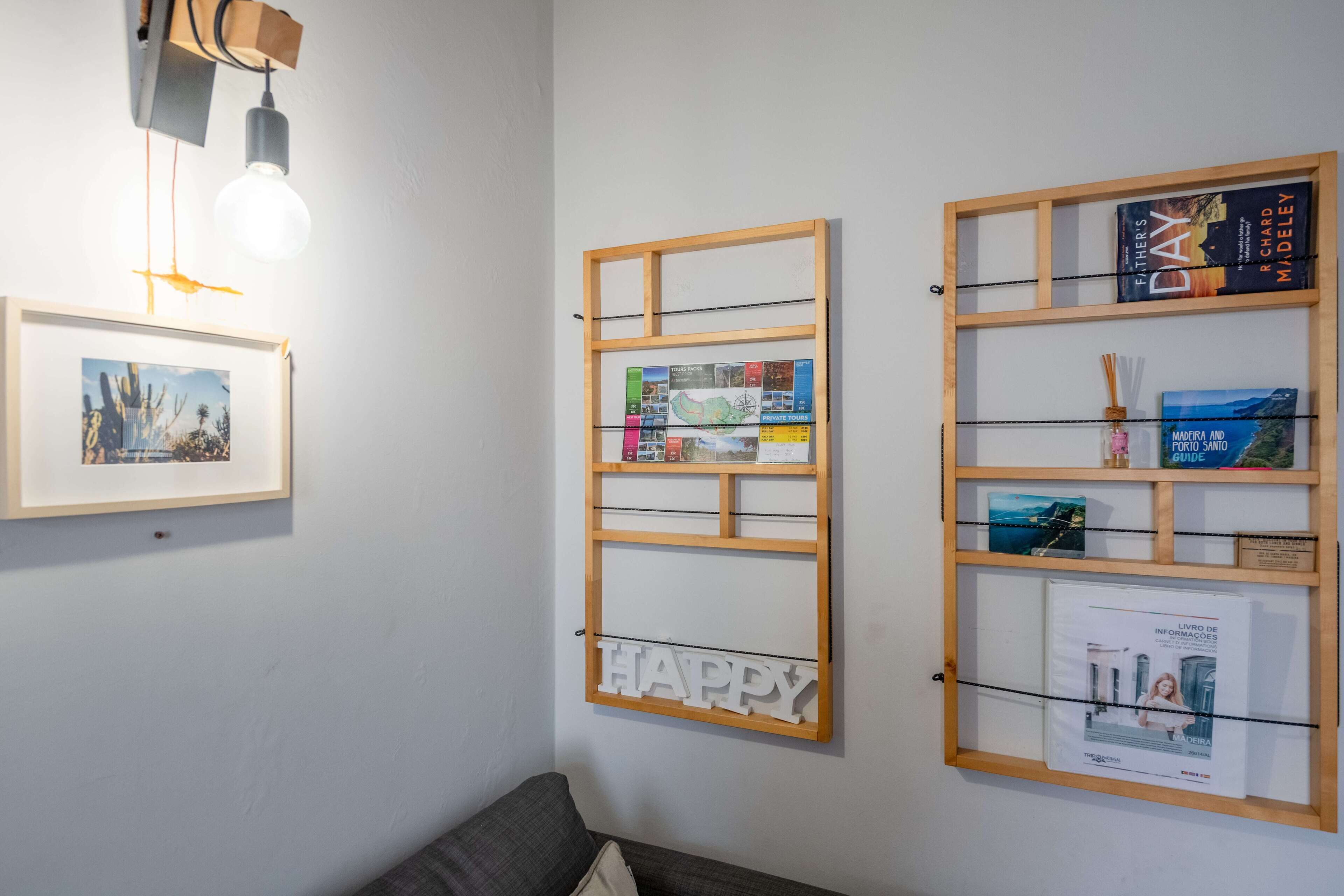 A room with a framed map, a 'HAPPY' sign, and a bookshelf with books and a guide.