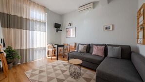 Una sala de estar moderna con un sofá gris, una mesa de centro redonda y una alfombra geométrica.