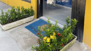 A building with a yellow facade, large windows, and a black door. - Pousada Girassol (Ipojuca)