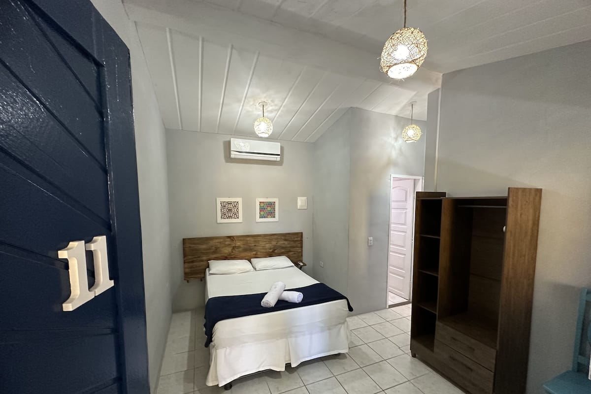 Un dormitorio con cama, armario y puerta con un número.