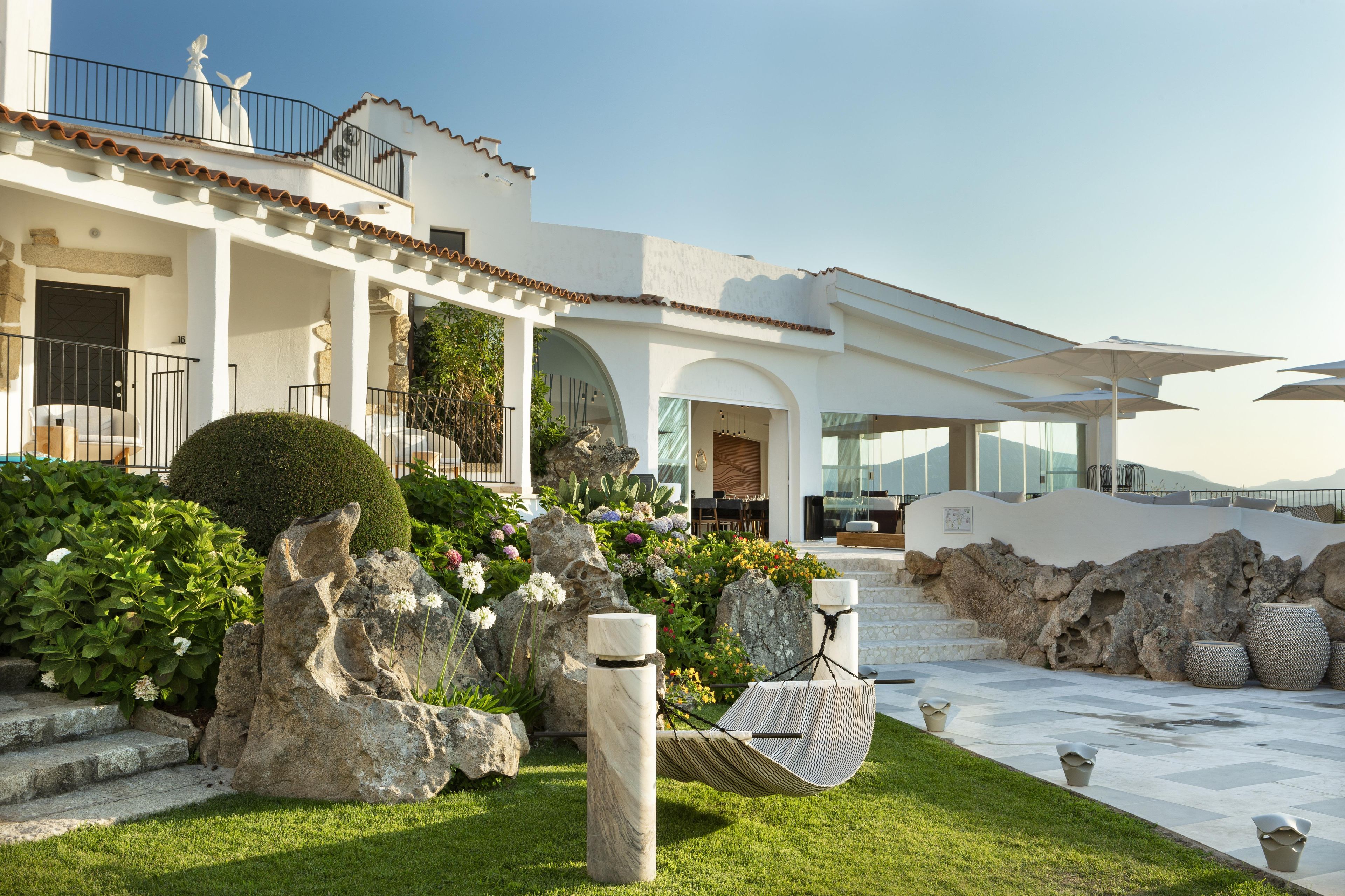 A modern house with a patio, outdoor seating, and a well-maintained garden.